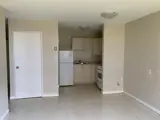 fridge, cabinets and stove set back into a kitchen area