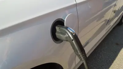 Electric car plugged into charging station