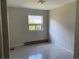 baseboard heater and window in bright bedroom