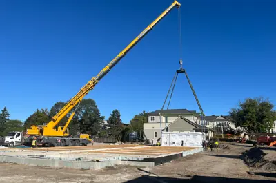 Crane placing the first module at the build site