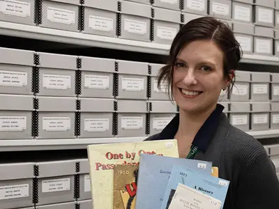 Archivist-Nicole-Aszalos-holds-examples-of-books-for-sale-in-the-Leap-Into-History-Book-Sale-web.jpg