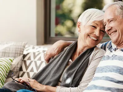 senior-man-woman-sit-on-couch.png