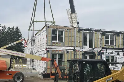 Crane placing a module in the second floor of the build