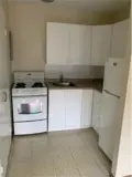 Stove, cabinets and fridge in kitchen area