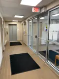 Lobby area with black floor mats in hallway leading to elevator doors