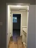 Hallway with doors leading to rooms and stairway to main floor