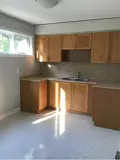 Spacious kitchen with window, cabinets and sink