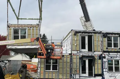 Crane placing a module in the second floor of the build