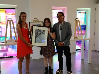 Isis-Belleman-McKeegan-center-is-awarded-the-grand-prize-for-the-2024-Teen-Photo-Contest-by-Vanitia-Campbell-left-and-Richard-Beland-right.JPG
